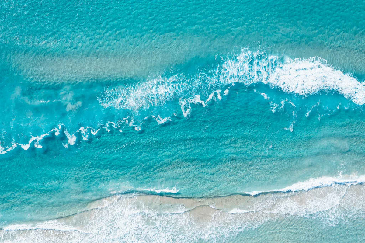 Top-down aerial view of turquoise water and white waves breaking over a sandbank at Surfers Paradise beach, Gold Coast