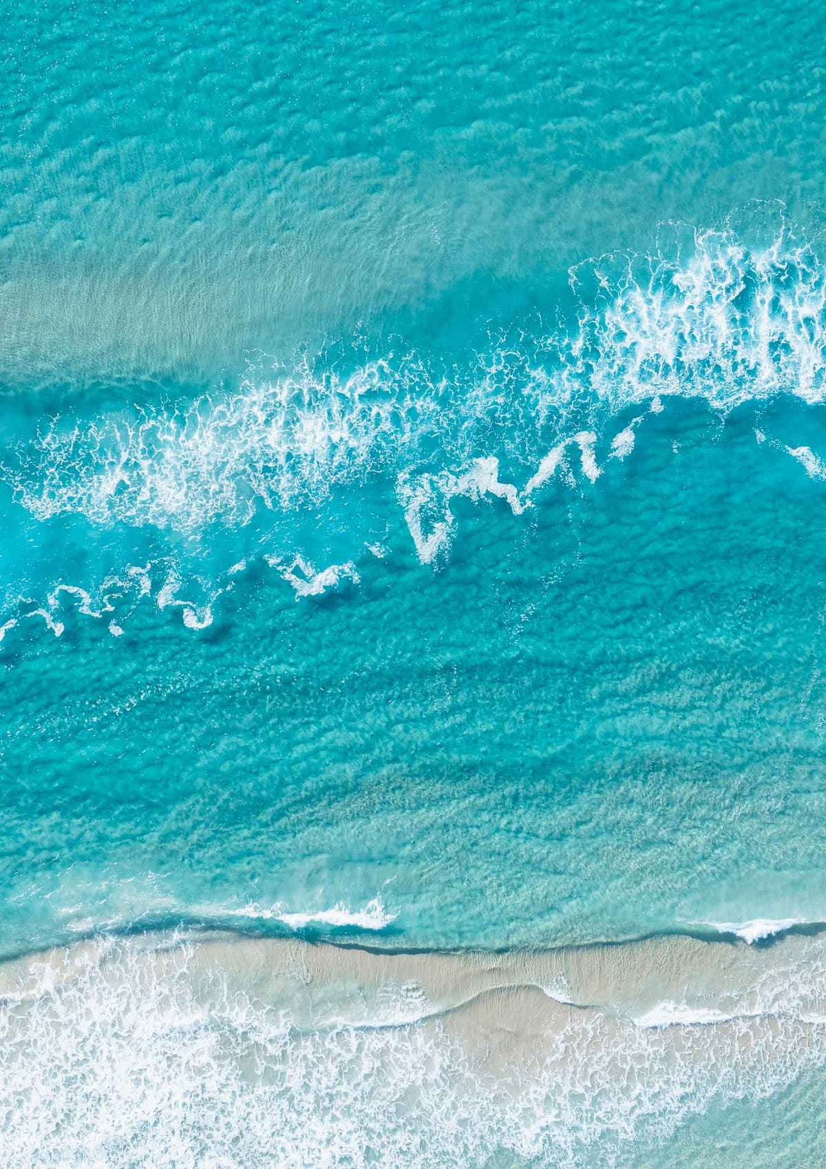 Top-down aerial view of turquoise water and white waves breaking over a sandbank at Surfers Paradise beach, Gold Coast